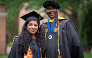 Two UMGC Graduates Smiling at Commencement 