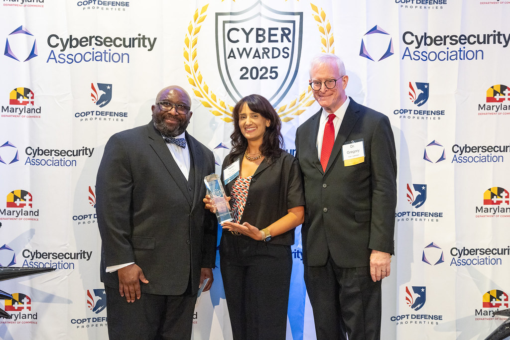Netta Squires (center), with UMGC Portfolio Vice President and Dean, School of Cybersecurity and IT, Calvin Nobles (left) and UMGC Special Assistant to President, Cybersecurity Greg Von Lehman (right) 